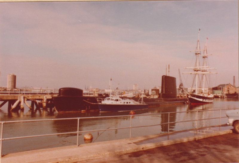 HMS Alliance docked in harbour with HMS Dolphin in the background. 