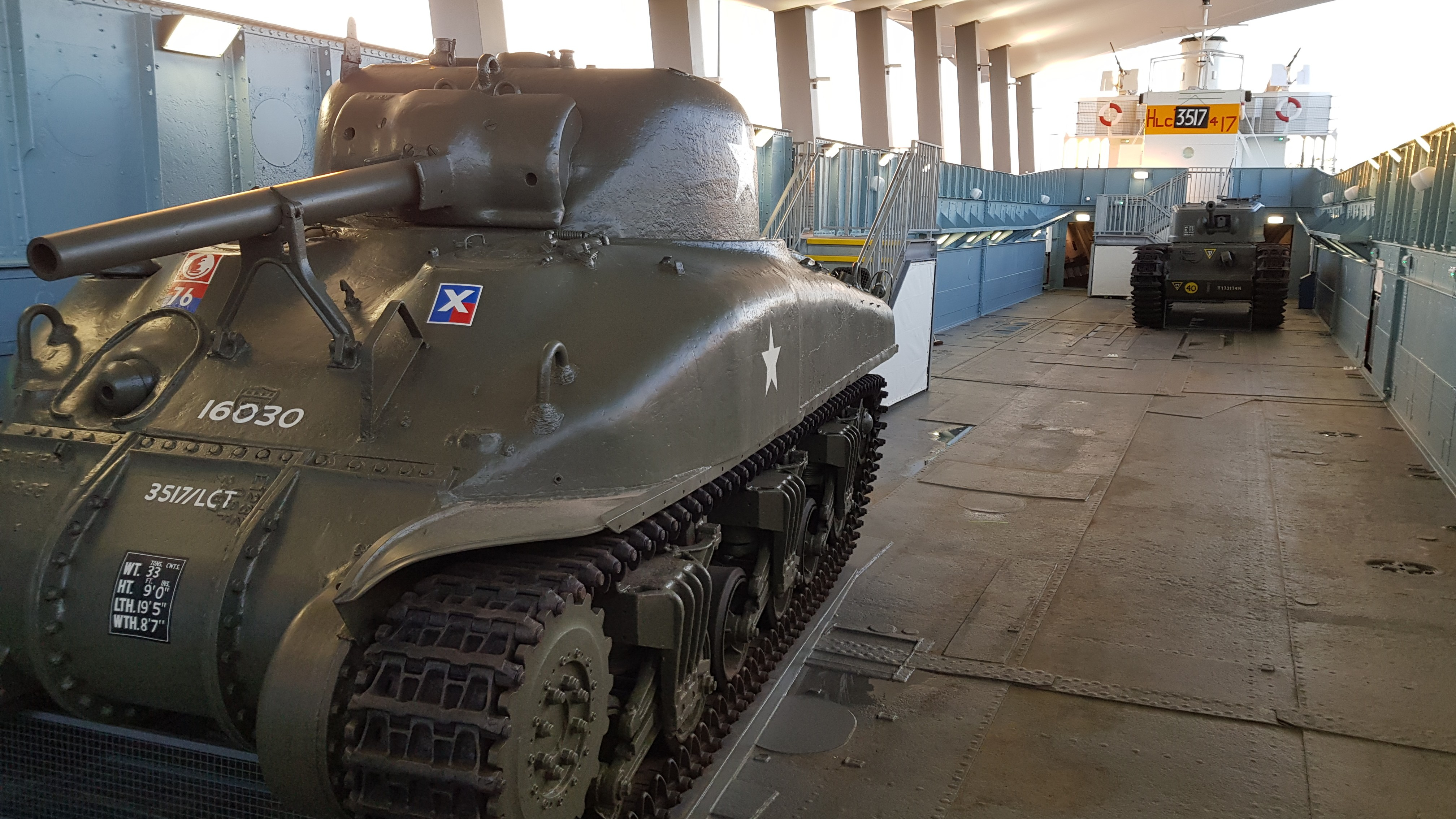 Two tanks onboard LCT 7074 D-Day landing craft on display under a canopy shelter in Portsmouth