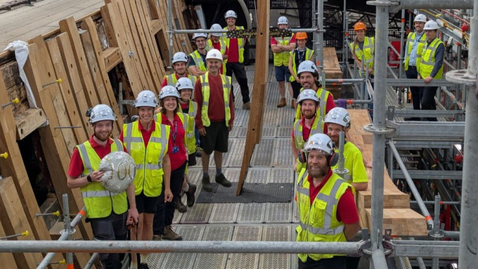HMS Victory's conservators gathered on her scaffolding to celebrate milestone. 