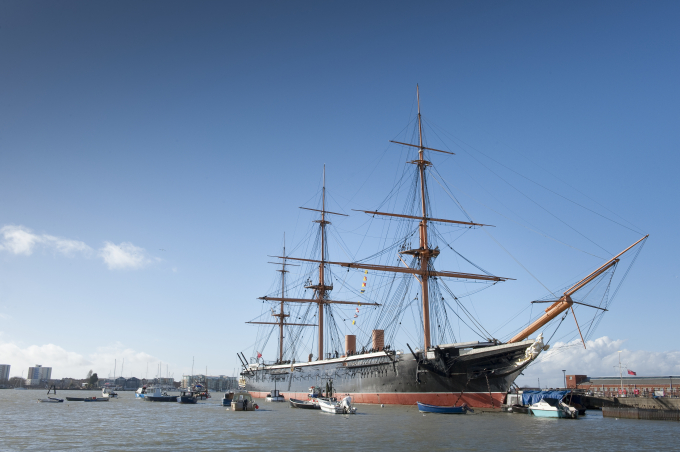 HMS Warrior lying resplendent in Portsmouth Harbour against a clear blue sky