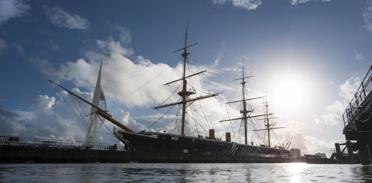 HMS Warrior sits in the water at the entrance of Portsmouth Historic Dockyard.