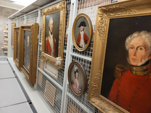 A wall covered in various paintings of naval officers in our collection.