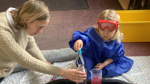 A child in goggles and an apron using a pipette during a science activity at 'Little Steamers: Space Explorers'