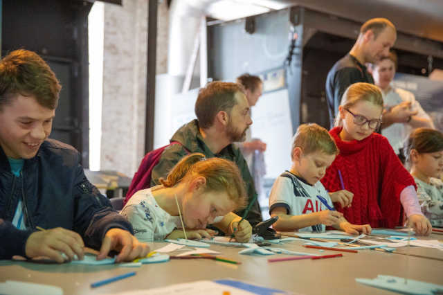 Group of children sitting at a table and drawing.