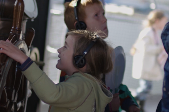 Two children wearing audio guide headphones. 