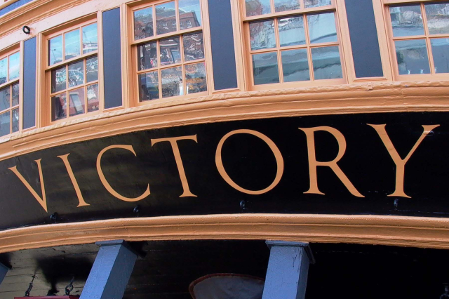 The word 'Victory' lettered across HMS Victory's stern. 