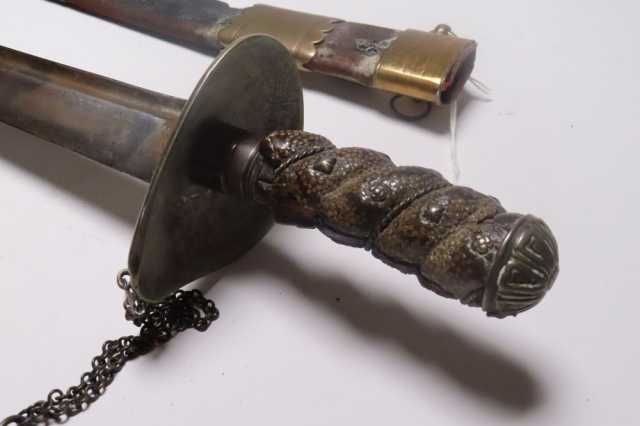 A close up of the cutlasses's decorated hilt. 