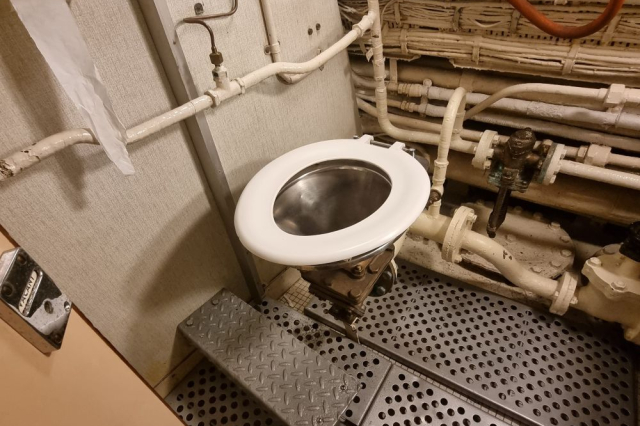 The industrial looking toilet onboard HMS Alliance. 