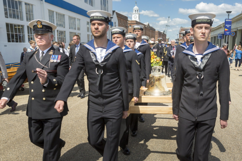 Current naval personnel carrying HMS Hood's bell through Portsmouth Historic Dockyard. 