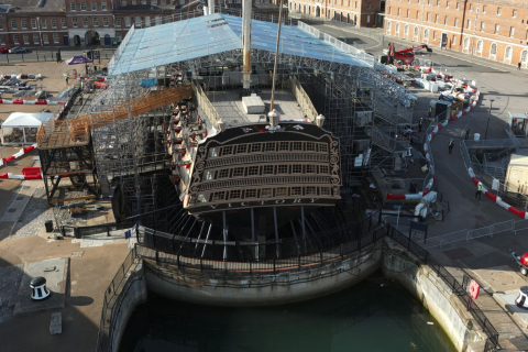 HMS Victory sits in dry dock with repair scaffolding to protect her from the weather.