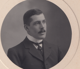 A black and white image of a man with a mousache