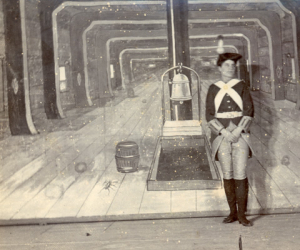 A stage replicating the inside of a naval ship with a female actor dressed as a Royal Marine. 