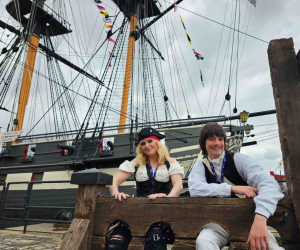 Two pirates sit in the stocks in front of HMS Trincomalee at Hartlepool. 