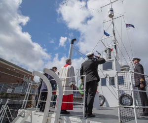 Naval Officers saluting the flag on the top deck of HMS M.33.