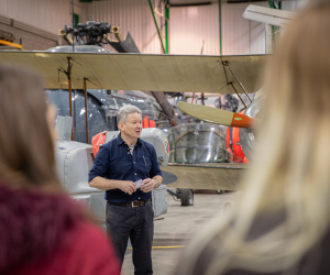 Tour guide stood in front of an aircraft