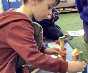 A child building structures with coloured wooden blocks during 'Little Steamers: Building Bridges