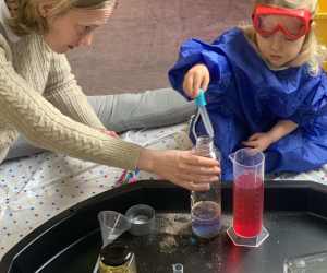 A child in goggles and an apron using a pipette during a science activity at 'Little Steamers: Space Explorers'