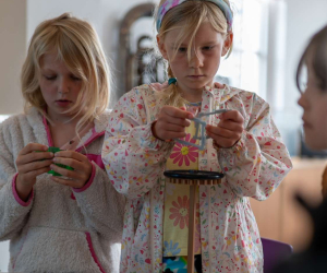 Two children concentrating on building with gears and plastic construction pieces