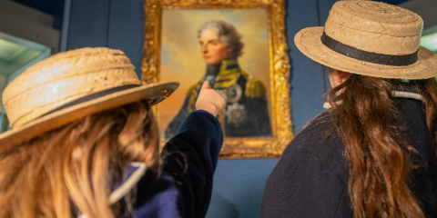 Two school girls learn about Vice Admiral Lord Nelson in the gallery dedicated to him. 
