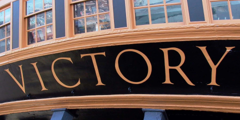 The word 'Victory' lettered across HMS Victory's stern. 