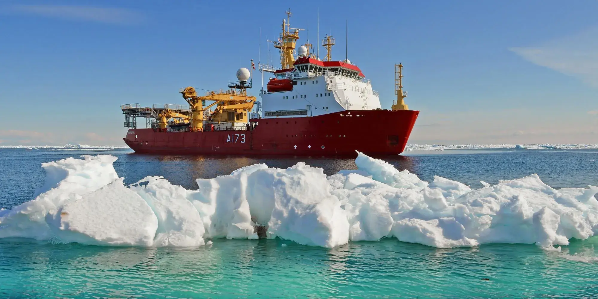 HMS Protector navigating past an ice burg whilst out at sea. 